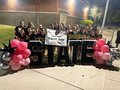 Cheer team holding Game Day banner