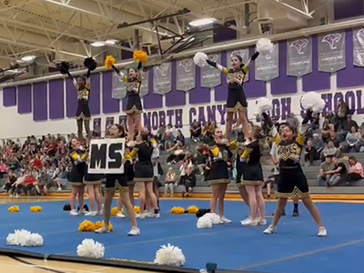 Cheer team holding up team members during a routine