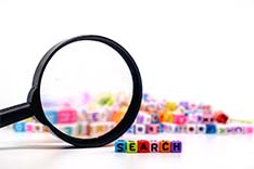 Magnifying glass with beads saying search